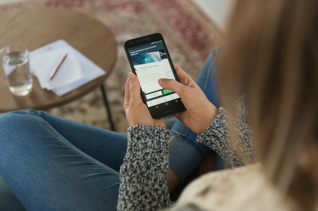 person using smartphone with ads